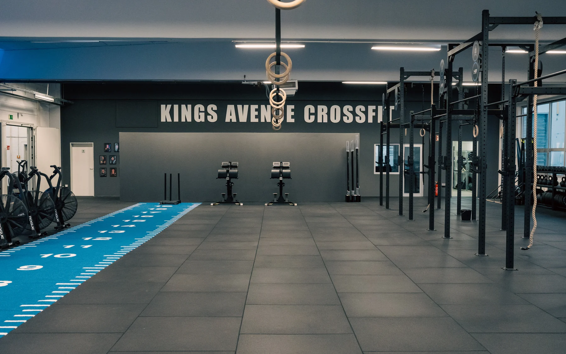 Open Gym bei Kings Avenue CrossFit Freie Trainingsfläche mit Rig, Turnringen und blauer Laufbahn für das Open Gym