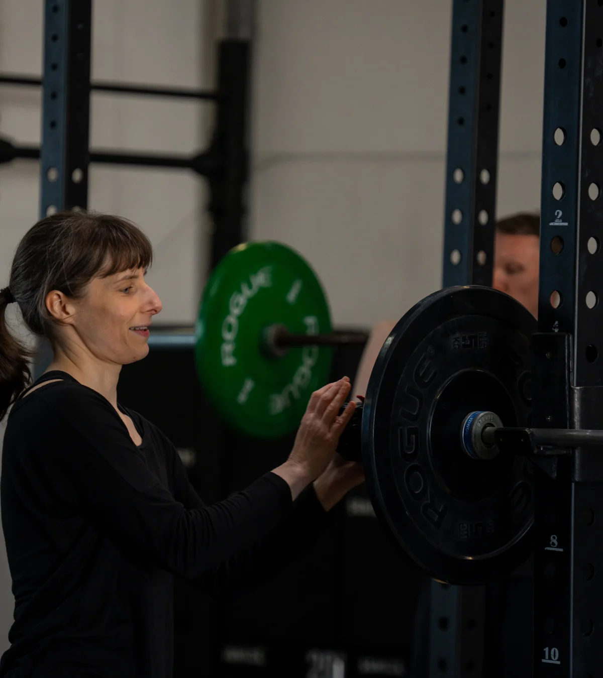 Athletin bereitet eine Langhantel für das Training vor Athletin bereitet eine Langhantel für das Training vor