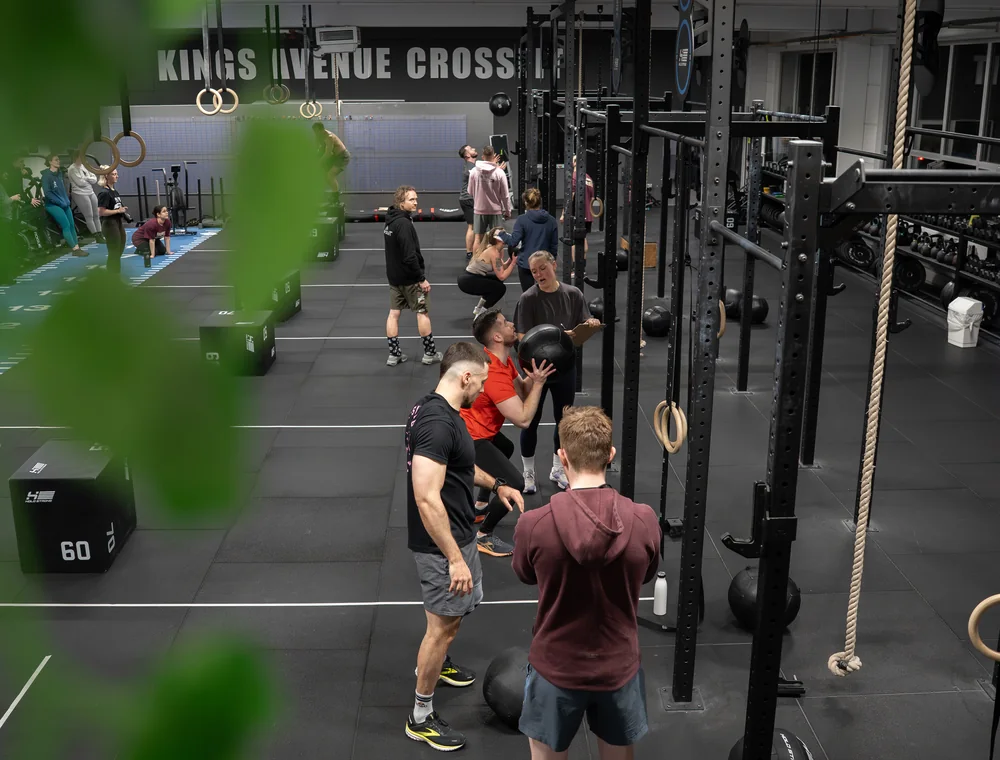 WOD bei Kings Avenue CrossFit Gemeinsames CrossFit-Training mit Medizinbällen und Übungen am Rig
