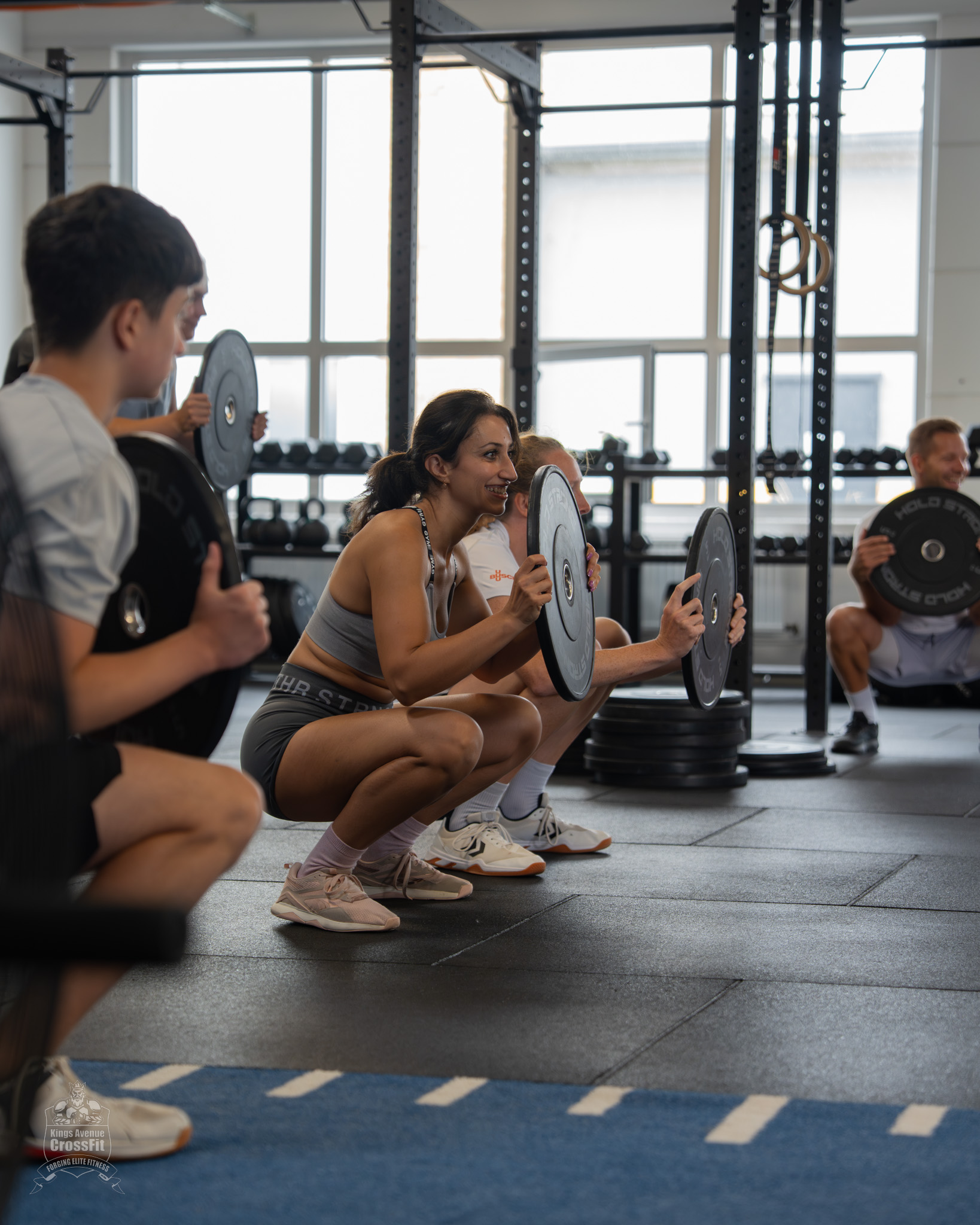 12.07.25 - Tag der offenen Tür00009 Teilnehmende üben Kniebeugen mit Gewichtsscheiben beim Tag der offenen Tür von Kings Avenue CrossFit
