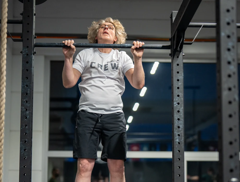 Gymnastics bei Kings Avenue CrossFit Athlet beim Klimmzug an der Reckstange im Gymnastics-Training